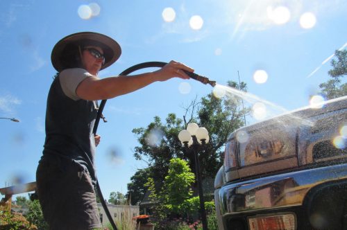 A Denver resident who asked that her name not be used washes her car in the Berkeley neighborhood July 12, 2019. It is one of dozens of neighborhoods in Denver whose water is delivered via lead service lines.
